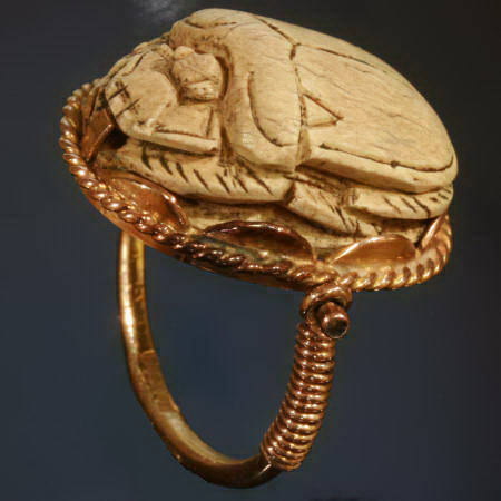 Typical Egyptian scarab ring with cartouched scarab set in golden swivel ring